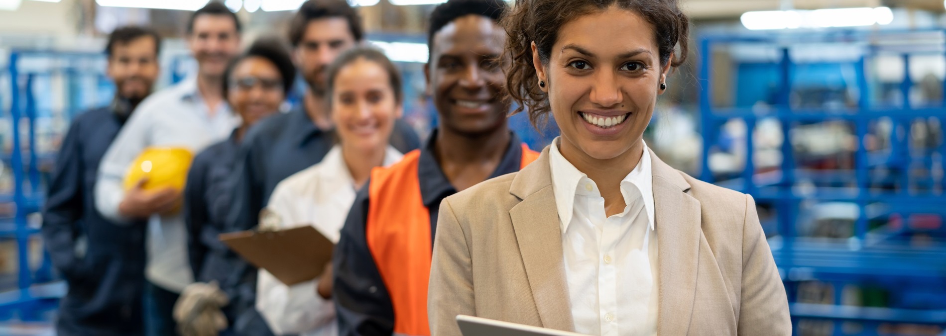 diverse team standing in diagonal line in a warehouse