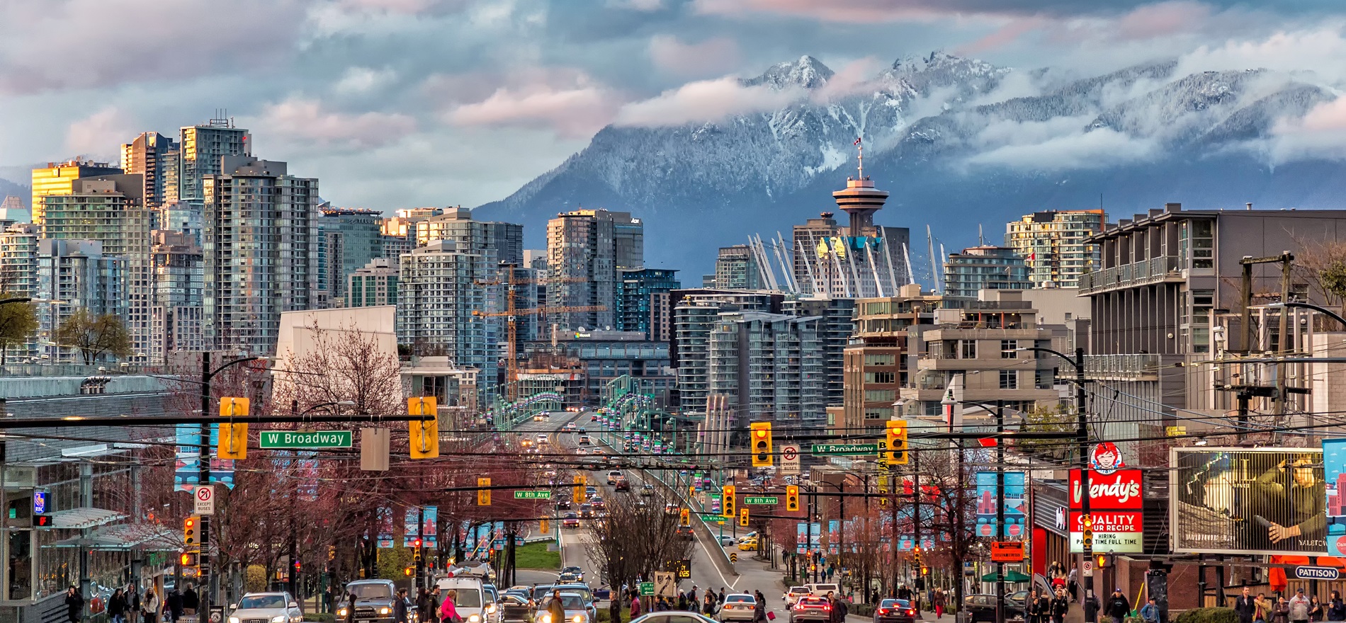 Busy downtown Vancouver intersection with view of snow-capped mountains