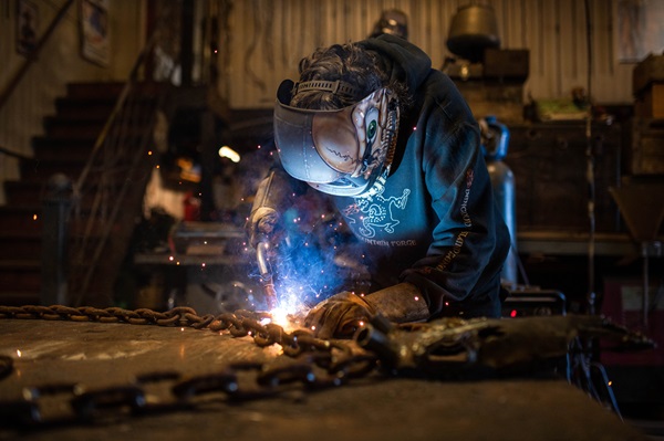 welder wearing customized welders helmet working on a project 
