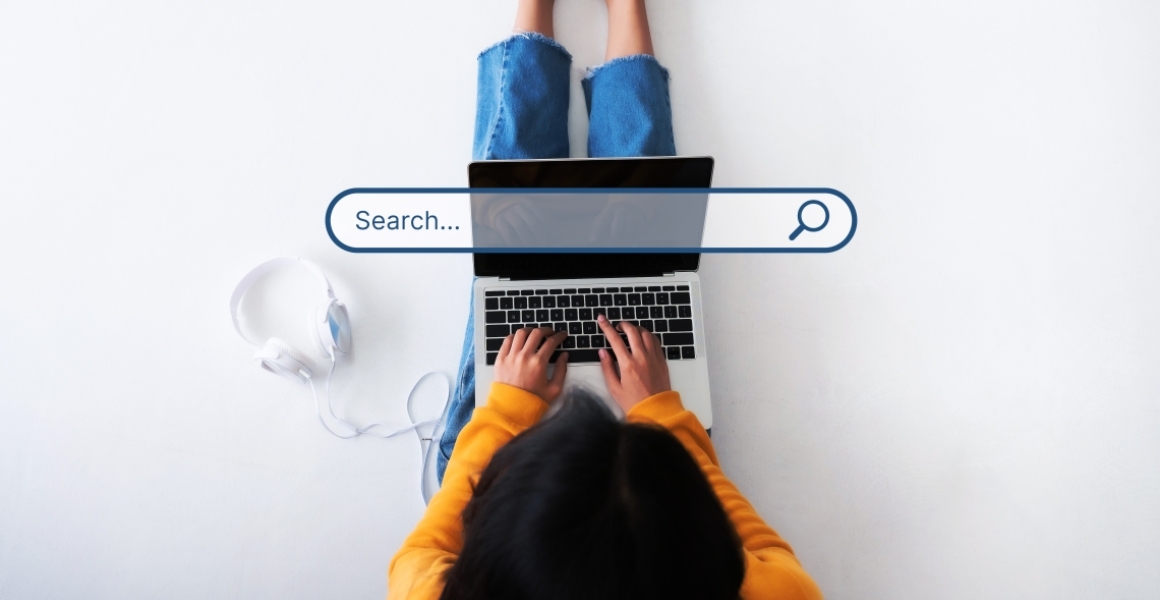 person typing into the search on their laptop