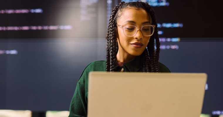 Black woman looking at a laptop
