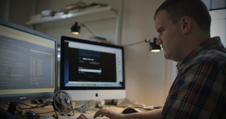 man coding at a computer