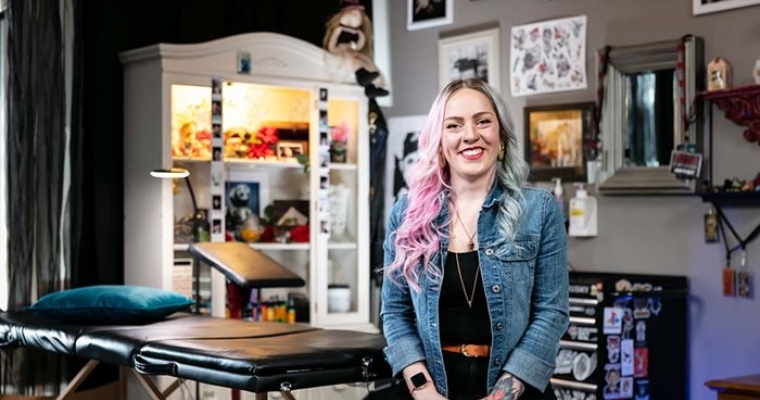 female tattoo artist sitting in a tattoo studio