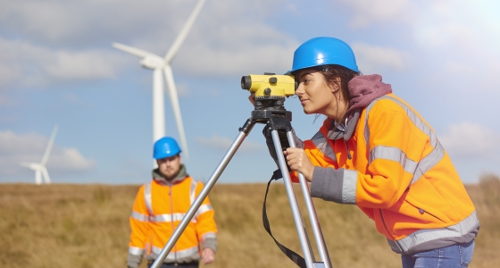 woman with hardhat using surveyor camera