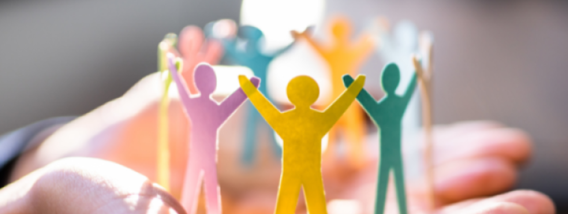 Multi-coloured cut-out paper people in a circle with arms raised 