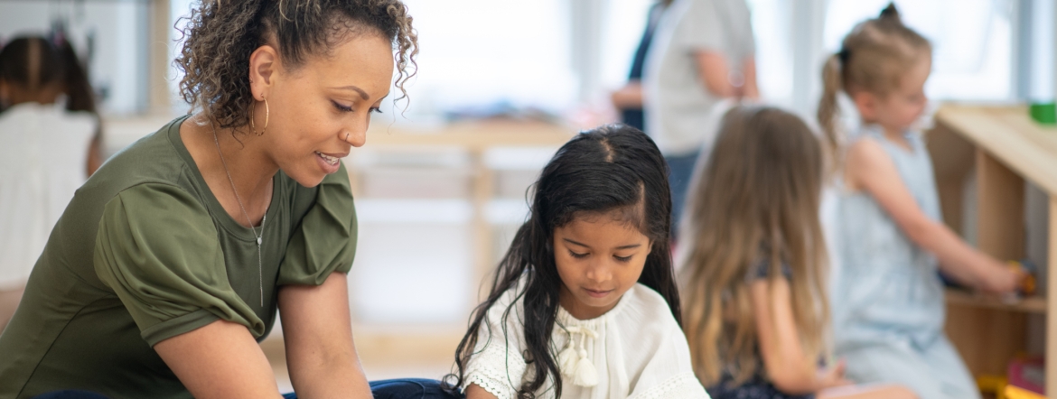 Early childhood educator playing magna tiles with young girl