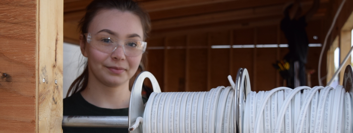 Kendra on the job as an electrician wearing safety glasses