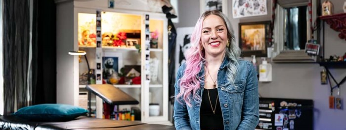 female tattoo artist sitting in a tattoo studio