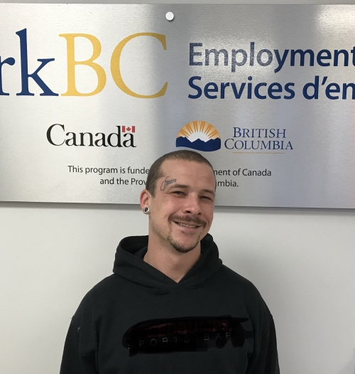 person smiling in front of a WorkBC Employment Services sign
