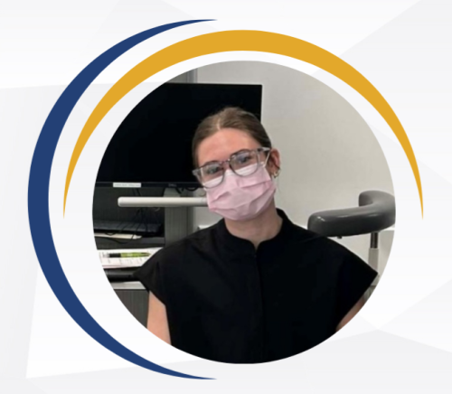 Female wearing glasses and medical mask next to computer