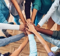 Diverse group of people with hands in a circle