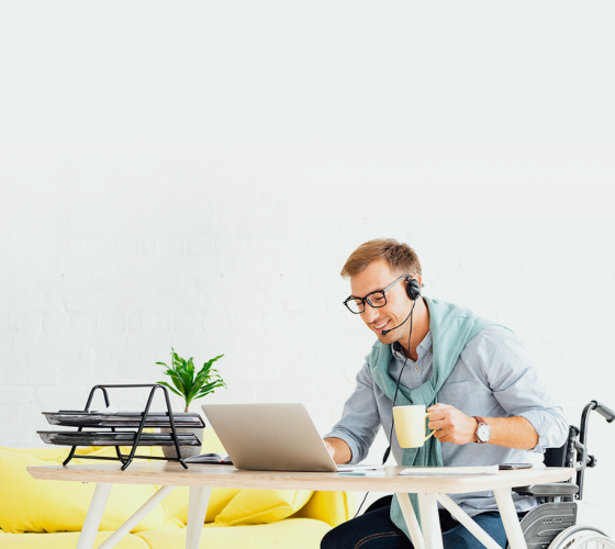 man in wheelchair with coffee and laptop