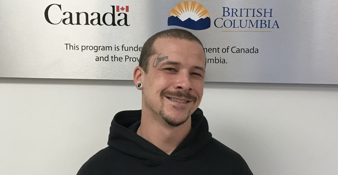 person smiling in front of a WorkBC Employment Services sign