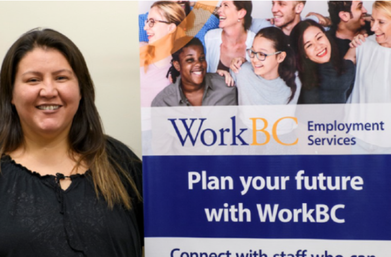 An Indigenous woman smiling and standing next to a WorkBC Employment Services sign that reads "Plan your future with WorkBC"
