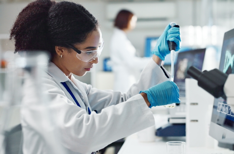 Black female scientist wearing safety apparel working in laboratory