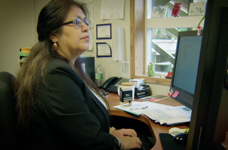 female bookeeper looking at computer monitor sitting in her office