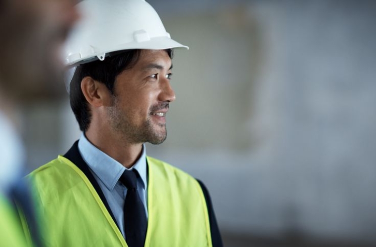 construction worker wearing a tie, safety vest and hard hat