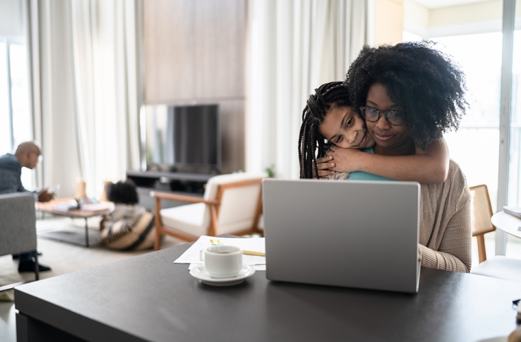 bipoc mom and daughter looking at laptop