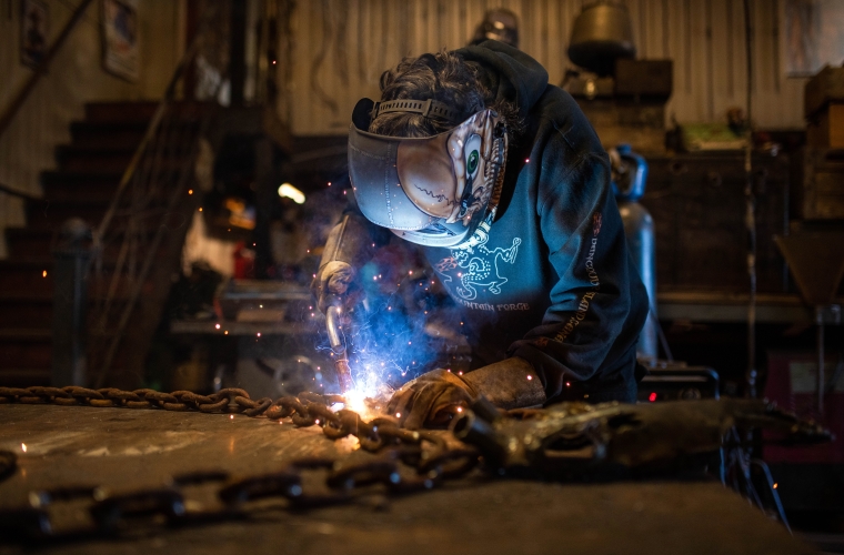 male blacksmith welding in a workshop