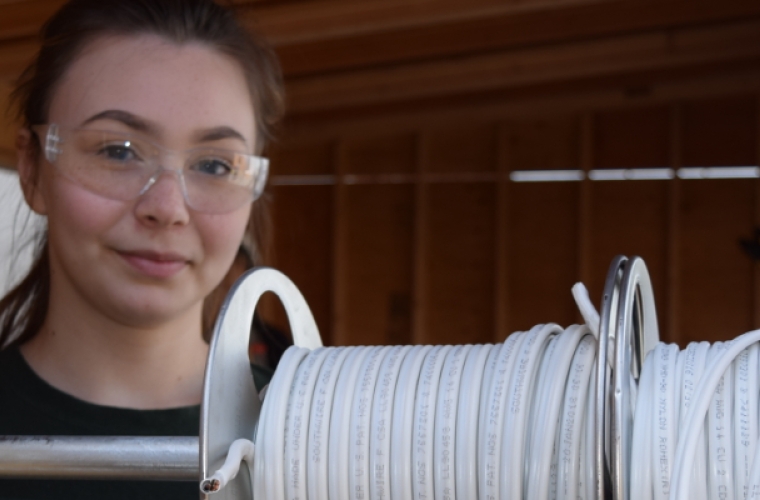 Kendra on the job as an electrician wearing safety glasses