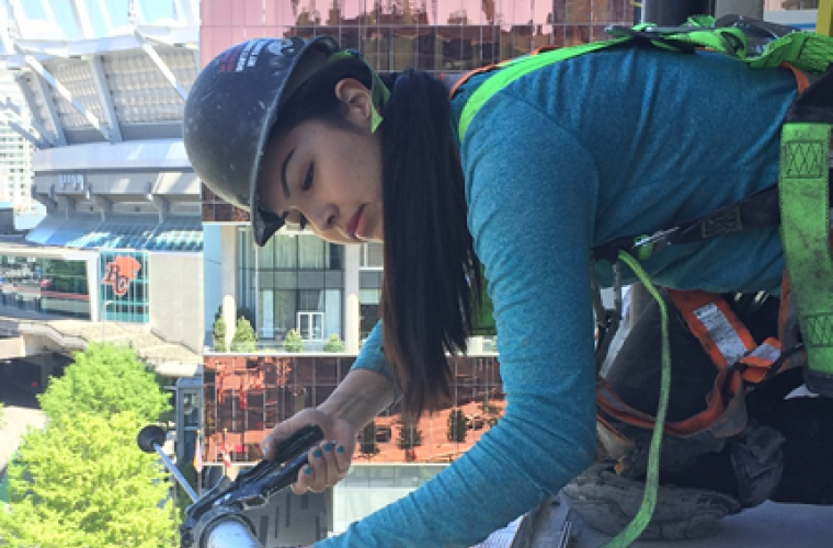 Rebecca Knot doing construction work with a hard hat and safety vest