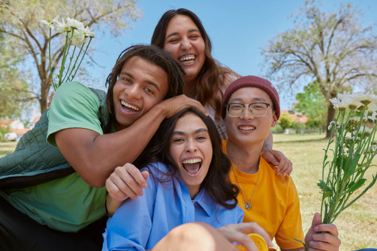 four people laughing and smiling towards the camera