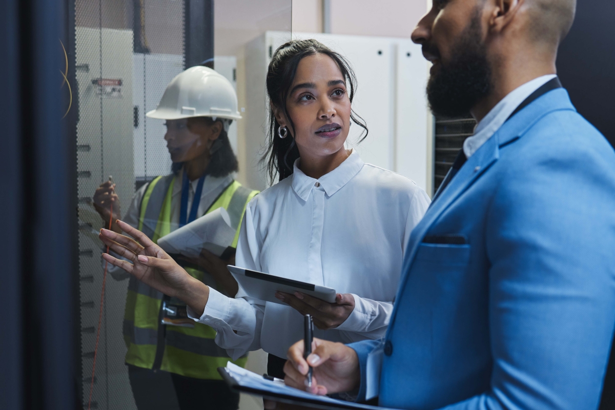 Male and female coworkers inspecting the equipment in a server room