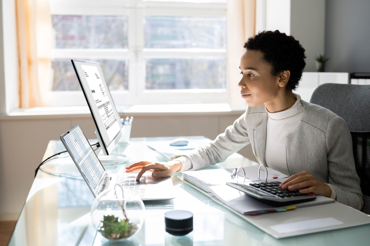 Black professional female working on financial documents on a computer