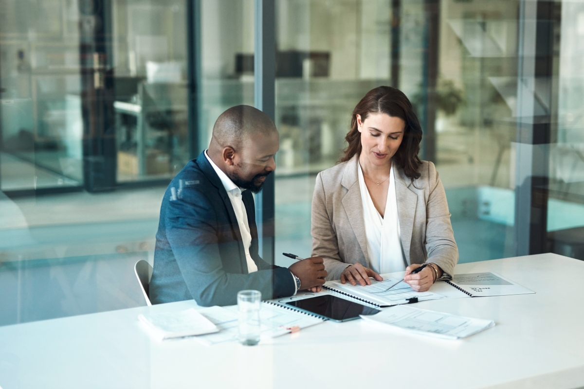 Male and female colleagues reviewing documents together in a boardroom