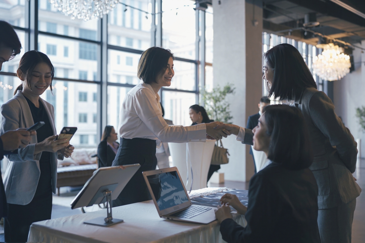 Asian participants registering at reception desk for a business conference  