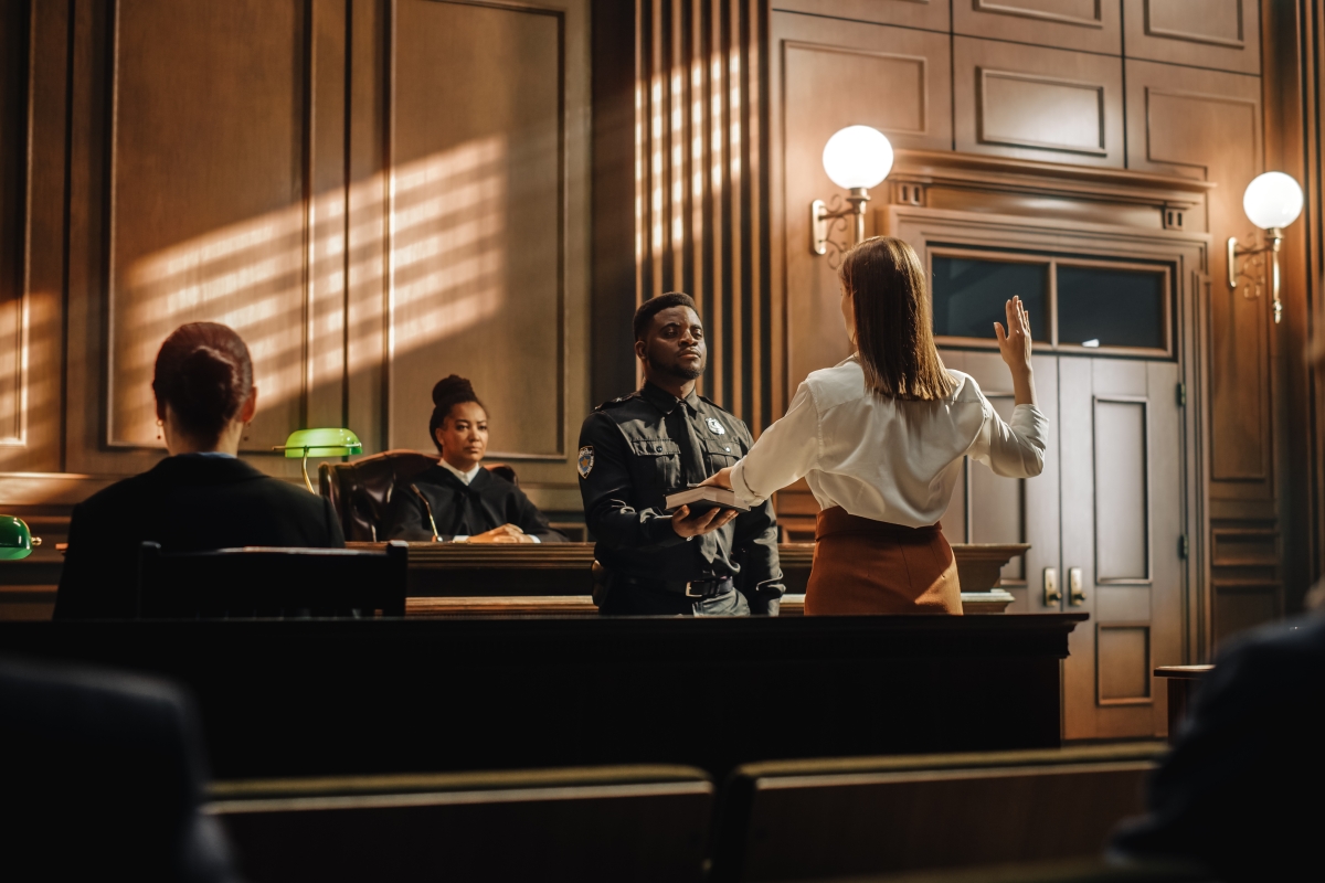 Black court clerk swearing in witness in the court room