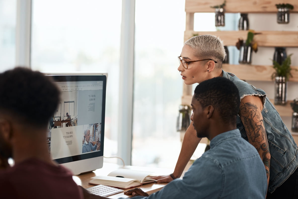 Diverse coworkers looking at a monitor together