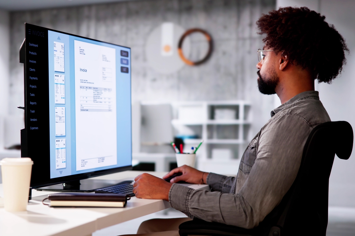 BIPOC male accountant reviewing invoice online  