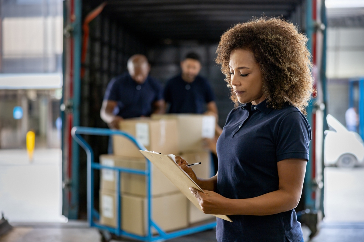 Black female supervising the shipping of cargo at a distribution warehouse