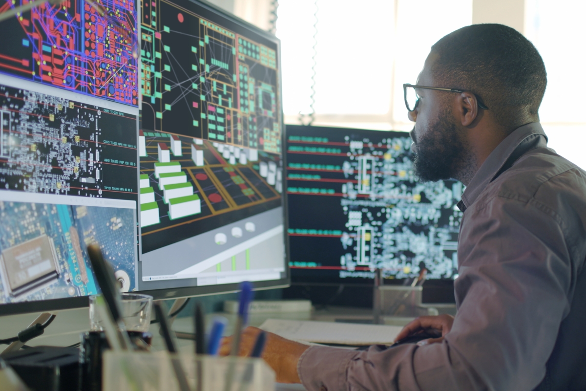Afro-Caribbean male working on his computer designing electronic circuit boards