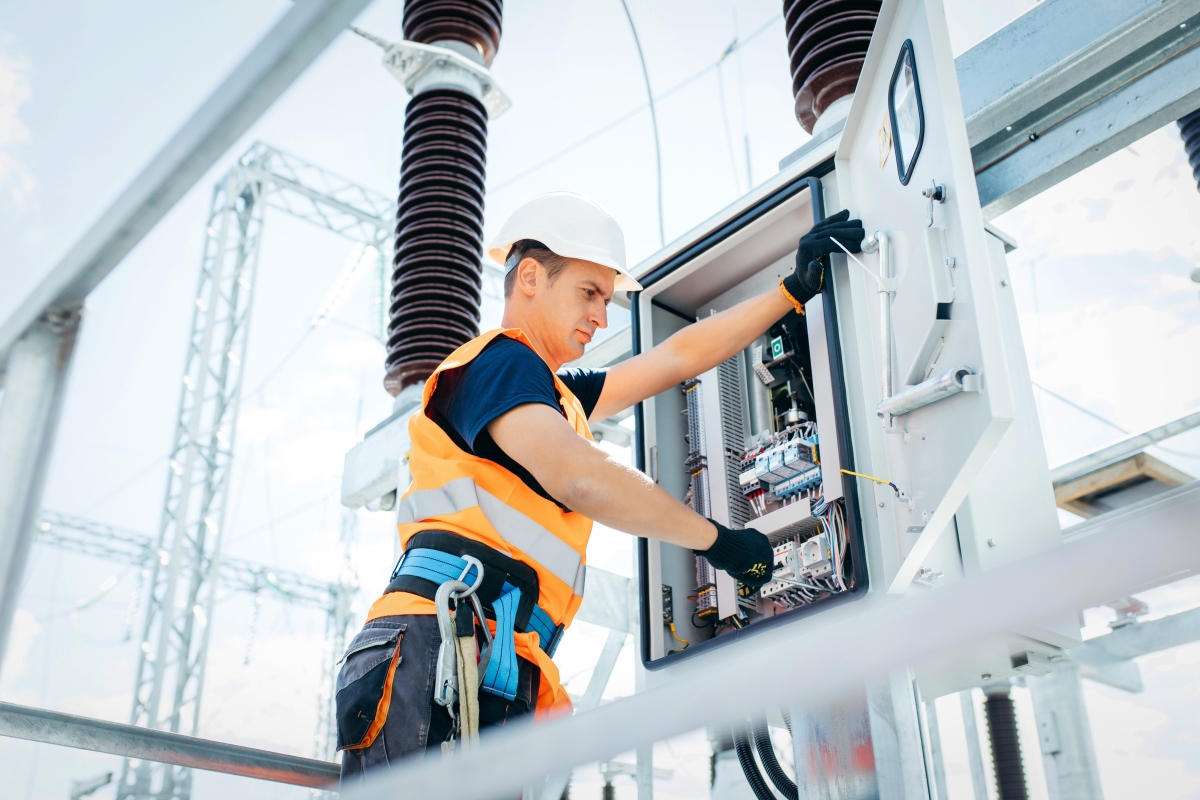 Male electrical technician working on an outdoor industrial circuit box