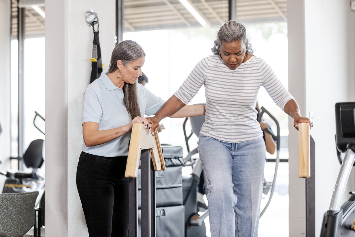 female physiotherapist assisting a patient to climb stairs