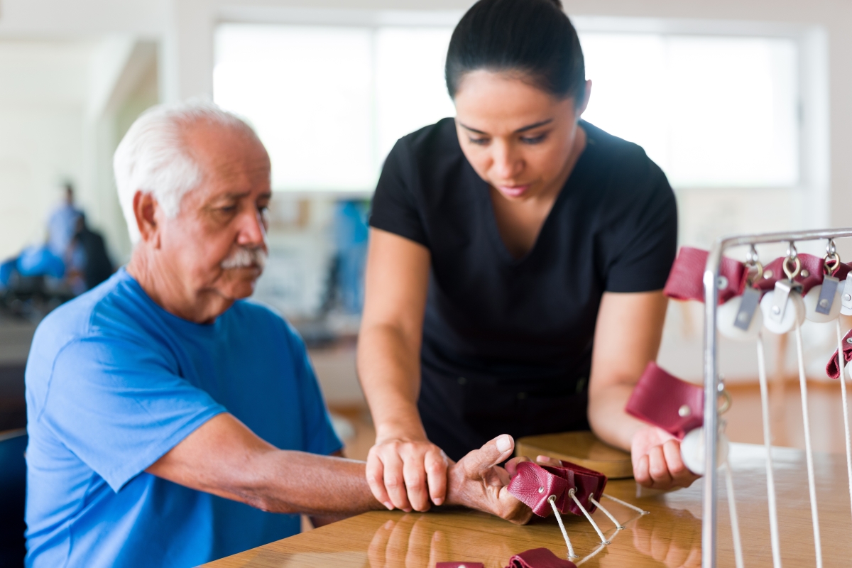 female occupational therapist working on hand exercises with a senior male patient