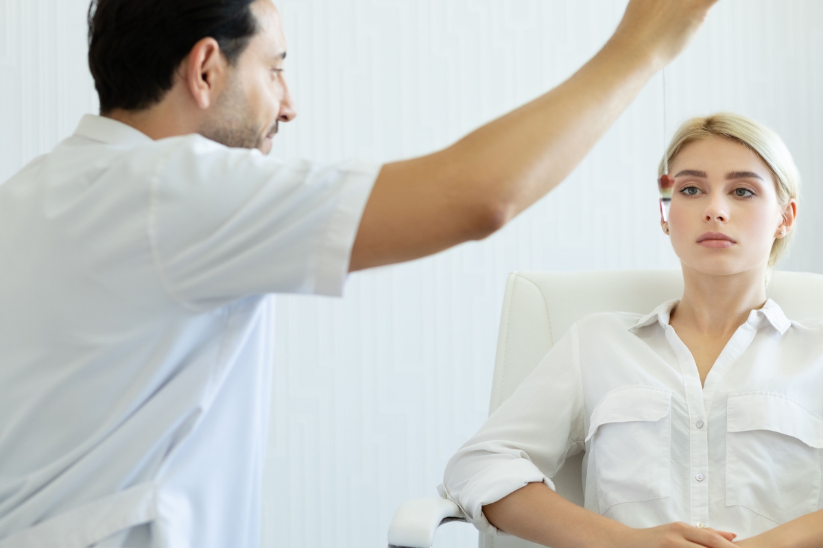 Male therapist using hypnosis therapy on young woman 