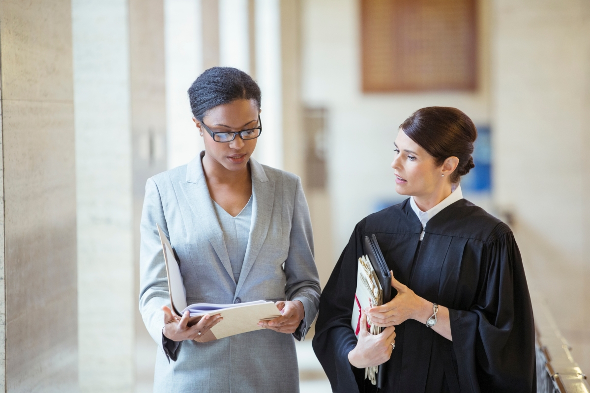 Female lawyer and judge talking in courthouse