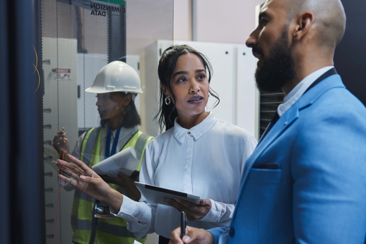Male and female coworkers inspecting the equipment in a server room.
