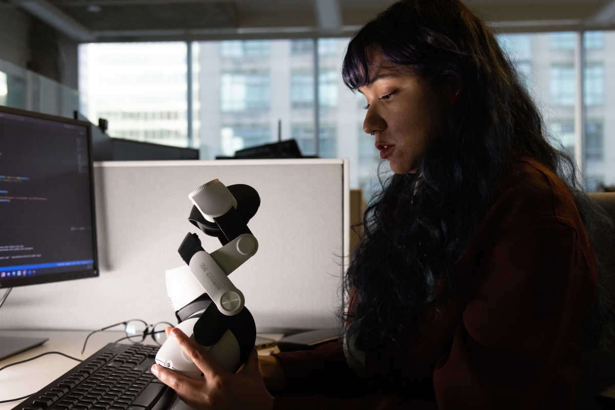 Female software developer looking in a VR headset.