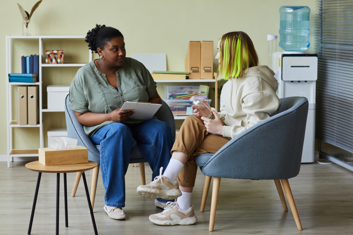 Black female career counsellor working with young female client.