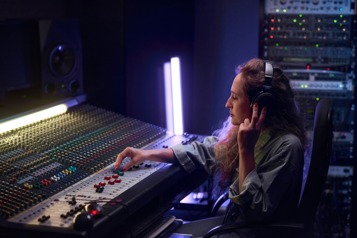 Caucasian female composing music in studio.