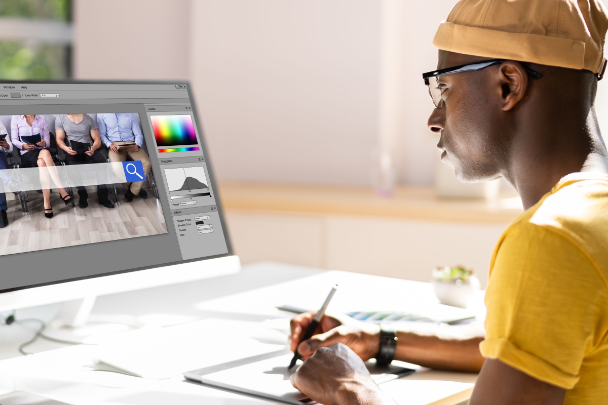 Black male designer editing photo on computer
