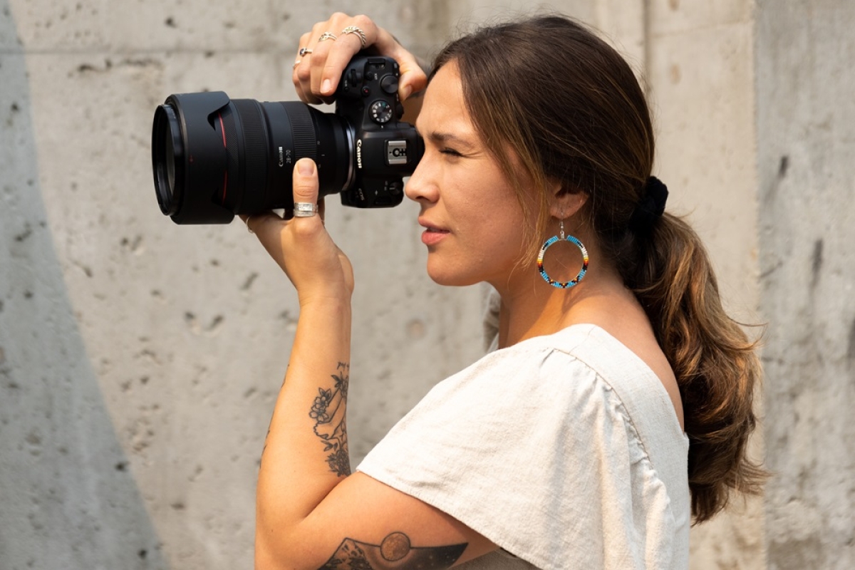 Female photographer taking photo with professional camera.