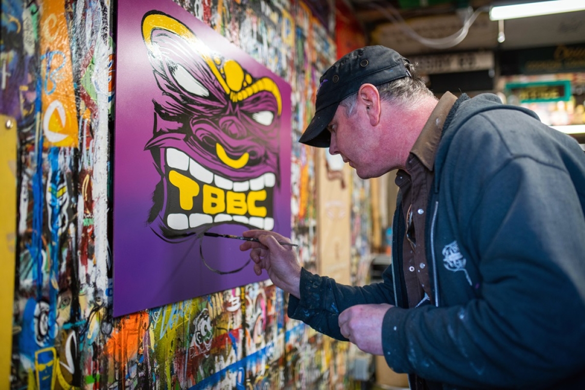 male artist creating signage in studio.