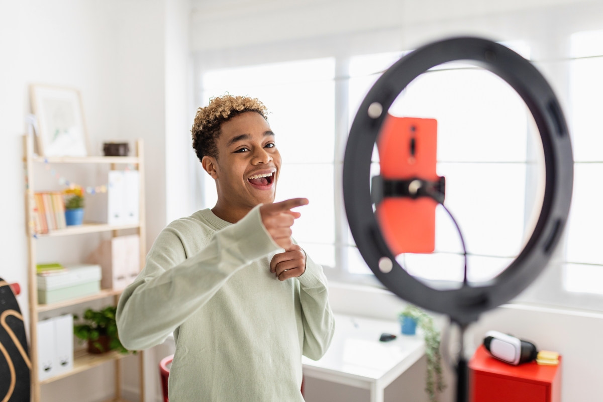 Young male recording online media video in his room.