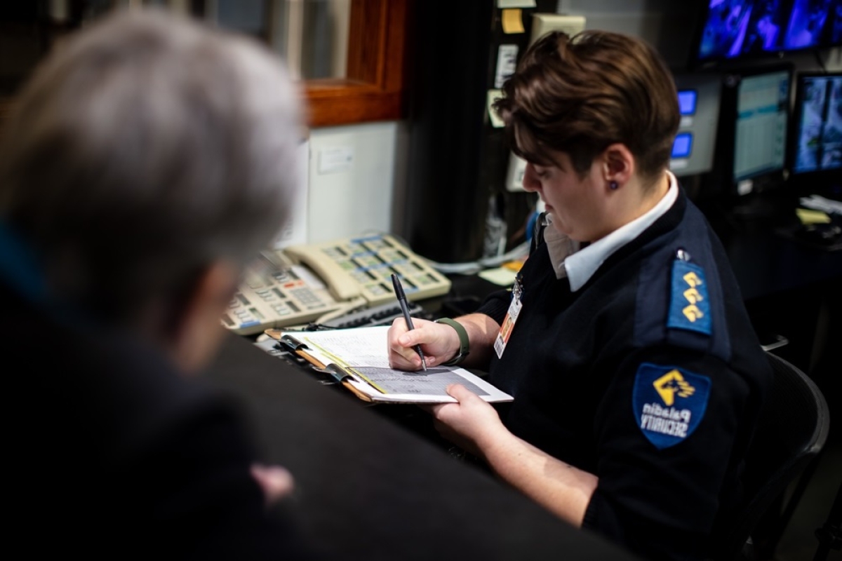 Female security guard completing paperwork while on duty.