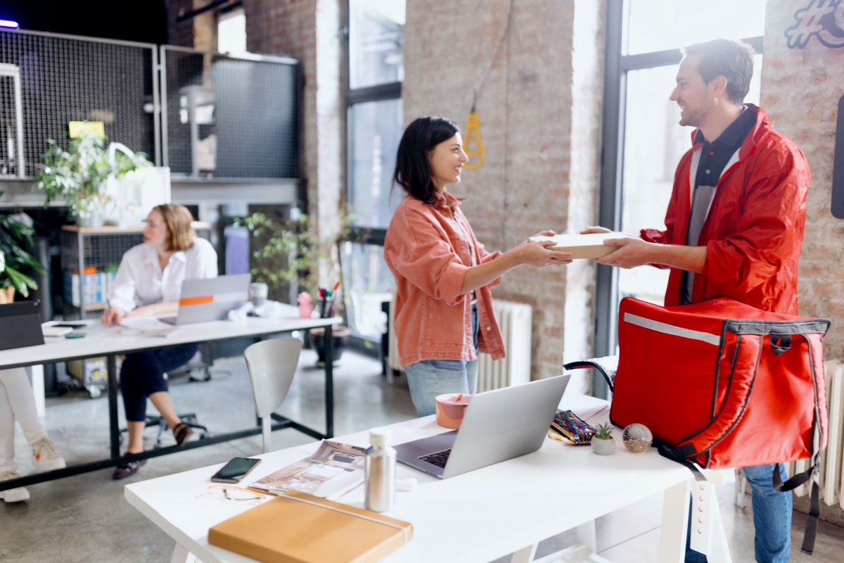 Woman receiving food to her office from a delivery guy.